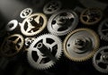 Interlocking metallic gears of varying sizes and shades of silver and bronze are arranged in a Royalty Free Stock Photo
