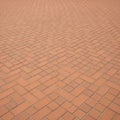Interlocking red bricks in a herringbone pattern cover a flat surface Royalty Free Stock Photo