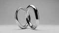 Interlocking Smooth Silver Rings Symbolizing Unity and Connection on a Neutral Background Royalty Free Stock Photo