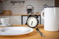 intermittent fasting concept alarm clock on kitchen table Royalty Free Stock Photo