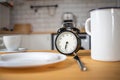 intermittent fasting concept alarm clock on kitchen table Royalty Free Stock Photo