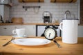 intermittent fasting concept alarm clock on kitchen table Royalty Free Stock Photo