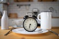 intermittent fasting concept alarm clock on kitchen table Royalty Free Stock Photo