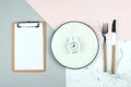 Intermittent fasting diet concept. Empty plate with alarm clock, note notepad. Flat lay, top view Royalty Free Stock Photo