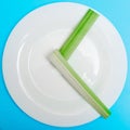 Intermittent fasting, diet concept. An empty plate as a dial and pods of a seler as a clock hands on a blue background Royalty Free Stock Photo