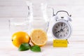 Intermittent fasting. Fasting time, alarm clock and lemon water on white table, diet food concept. Fat loss concept. Weight loss