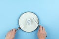 Intermittent fasting, keto diet concept. Empty plate with white alarm clock. Flat lay, top view Royalty Free Stock Photo