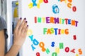 Intermittent fasting diet concept with woman standing in front of fridge starring at food