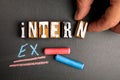 Intern and Extern concept. Wooden letter blocks on blackboard background