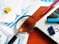 Internal business audit. Magnifying glass on the pile of financial reports Royalty Free Stock Photo