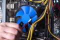 Internal parts of an old personal computer. Dusty motherboard, video card and fan. The master cleans the PC cooler from Royalty Free Stock Photo