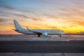 International Airlines Plane Parking Outside The Terminal In The Airport. White Passenger Airplane Side View, Sunset