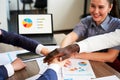 International business team showing unity with their hands stacked together in pile. Black african-american hand on top Royalty Free Stock Photo