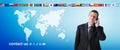 International contact us concept, businessman with mobile phone isolated on world map background, flags icons and contact symbols Royalty Free Stock Photo