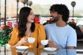 International dating. Happy couple enjoying tasty coffee in cafe