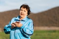 International Day of Older Persons. Portrait of an elderly smiling woman using a smartphone in her hand. The concept of Royalty Free Stock Photo