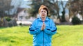 International Day of Older Persons. Portrait of an elderly woman in sportswear doing yoga in a park. Grass in the