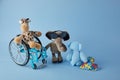 International day of persons with disabilities. Wheelchair with toys sign of different disabilities on blue background.