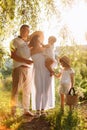 International Family Day. Young mother, father spending time with precious two child daughters in the summer park on Royalty Free Stock Photo