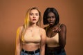 International female`s couple in beige bra looking at camera with frightened expression, shocked and terrified, african Royalty Free Stock Photo