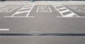 International handicap symbol in a parking lot of a shopping center. The space is clearly indicated on both sides by additional