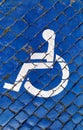 International handicapped symbol painted in bright blue on a paving street parking space. Royalty Free Stock Photo