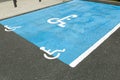 International handicapped symbol painted in bright blue on a shopping center parking space. The space is clearly marked on either Royalty Free Stock Photo