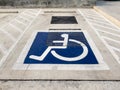 International handicapped wheelchair or Disabled parking symbol painted in bright blue on parking space