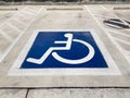 International handicapped wheelchair or Disabled parking symbol painted in bright blue on parking space Royalty Free Stock Photo