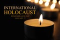 International Holocaust Remembrance Day January 27. Burning candle on table in darkness, closeup