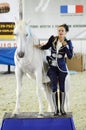 International Horse Exhibition Moscow Ridding Hall Woman jockey in a dark blue suit near to a horse.