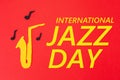 International Jazz Day. Silhouette of a saxophone from which melodies flew out, on a red background, cutted out of felt. Flat lay