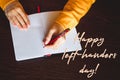 International left-handers day. Holiday August 13th. Woman lefty writes in notebook