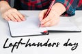 International left-handers day. Holiday August 13th. Woman lefty writes in notebook