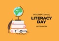 International literacy day banner poster with feather, globe, earth, glasses and books on orange color background