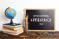 International Literacy Day. Chalkboard, a globe, a stack of books and school supplies