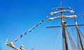 International maritime signal flags on a flagpole on a sailing ship with a blue sky in the background Royalty Free Stock Photo