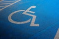 International markings for a handicapped parking, Disabled symbol sign on blue asphalt in parking space