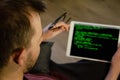 International Programmers Day. Caucasian man programs on the tablet at home. Developing programming and coding technologies. Royalty Free Stock Photo