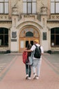 International students couple walking to the university building hugging each other, wearing stylish clothes Royalty Free Stock Photo