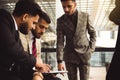 An international team of successful young business men in suits at a meeting are discussing the implementation of Royalty Free Stock Photo