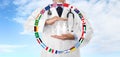 International travel medical insurance concept, doctor`s hands protect a family icon with flags, on blue sky Royalty Free Stock Photo