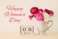 International women day concept with beautiful flowers in the vase and date on wooden table. Royalty Free Stock Photo