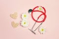 International Women`s Day card with stethoscope, hearts and chrysanthemum flowers in the form of eight on pink background