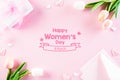International Women`s Day concept. Pink and white tulips with gift box and paper tag text on pink pastel background. Top view fla