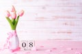 International Womens day concept. Pink tulips and red heart with March 8 text on wooden block calendar on white wooden background Royalty Free Stock Photo