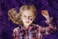 International world epilepsy illness awareness day. Cute pretty blonde Caucasian girl with small violet purple paper heart on