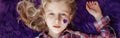 International world epilepsy illness awareness day. Cute pretty blonde Caucasian girl with small violet purple paper heart on her