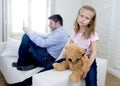 Internet addict father using mobile phone ignoring little sad daughter bored hugging teddy bear Royalty Free Stock Photo