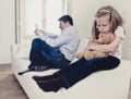 Internet addict father using mobile phone ignoring little sad daughter bored hugging teddy bear Royalty Free Stock Photo